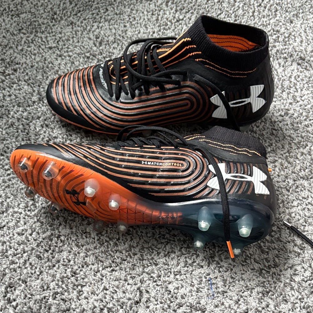Never worn Soccer cleats Under Armour Black and Orange Cleats brand new